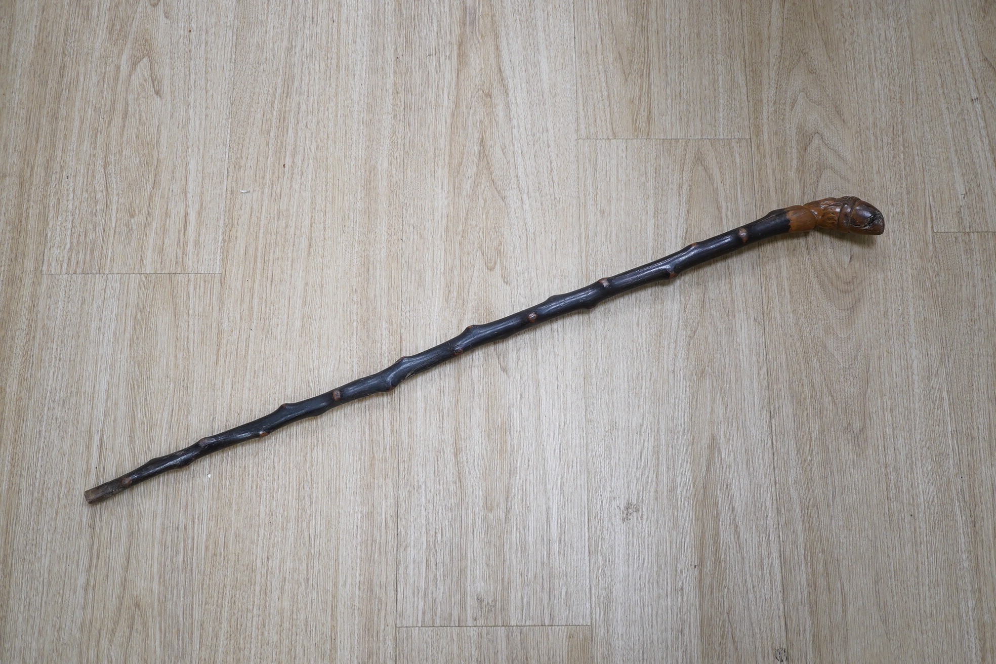 A carved rootwood walking stick, with carved novelty ‘Punch’ style head handle. 81cm high. Condition - some damage on stick.